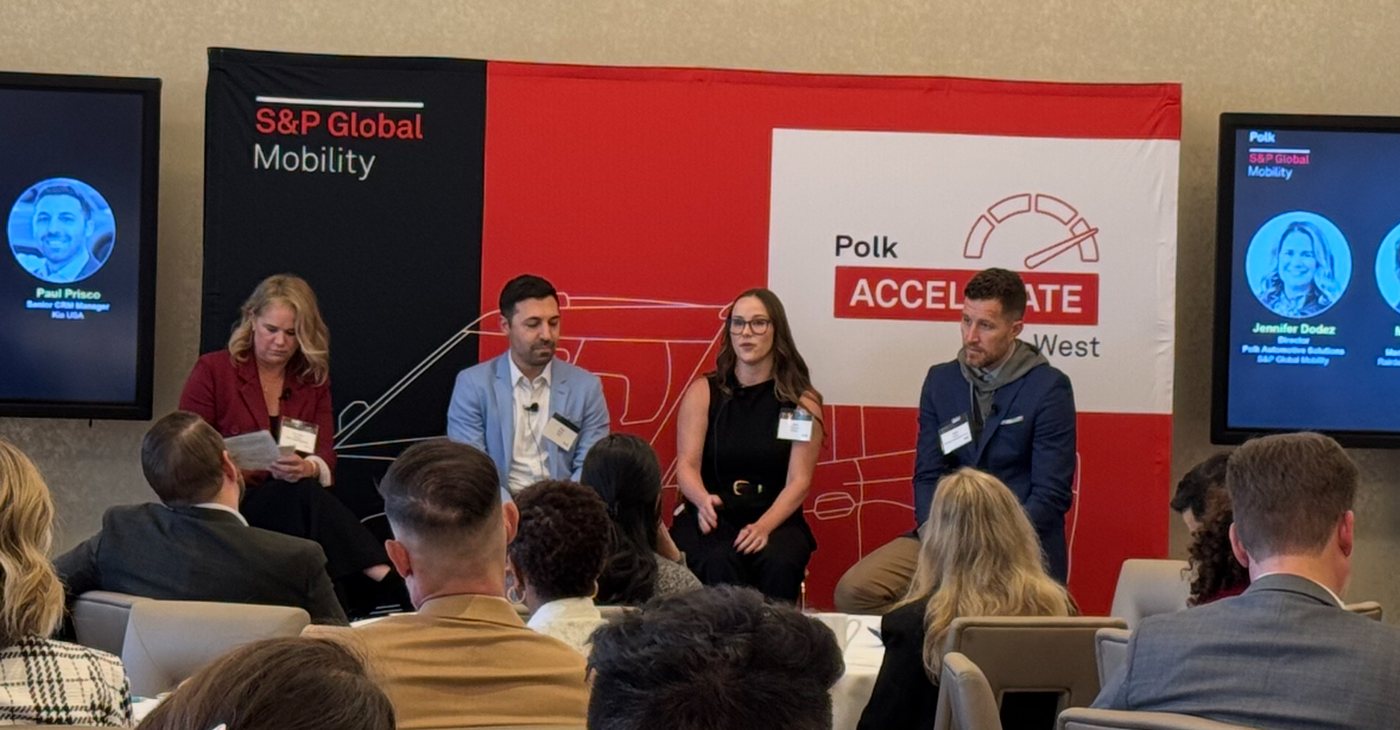 Julie Vezzani speaking on a panel at Polk Accelerate, an S&P Global Mobility event, in front of a seated audience.